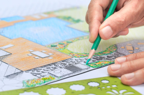 personne en train de dessiner un aménagement de jardin au crayon de couleur